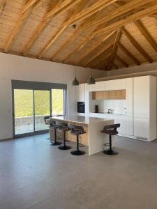 a kitchen with a table and stools in a room at Contemporary villa with pool and sea view in Poulithra