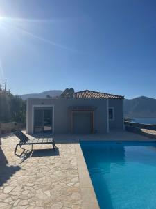 a villa with a swimming pool and a house at Contemporary villa with pool and sea view in Poulithra