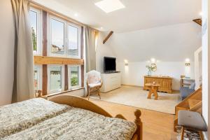 a bedroom with a bed and a desk and windows at Ferienwohnung in Anni's Ferienhaus in Großaltenstädten