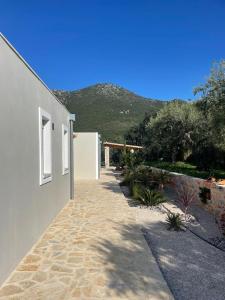 a pathway next to a building with a mountain in the background at Contemporary villa with pool and sea view in Poulithra