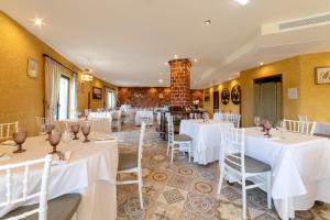 a dining room with white tables and chairs at Hotel Cerro La Nina in Beceña