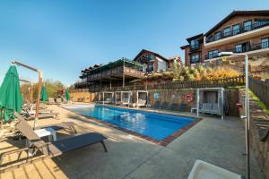 a swimming pool with chairs and a building at Hotel Cerro La Nina in Beceña