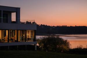a house with the sunset in the background at Bianca Relais, by R Collection Hotels in Oggiono +49 photos