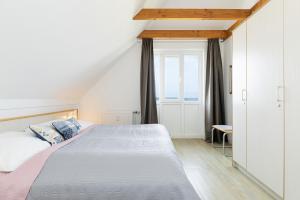 a white bedroom with a bed and a window at Strandhotel Laboe Nr 35 in Laboe