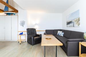 a living room with a couch and a chair at Strandhotel Laboe Nr 35 in Laboe