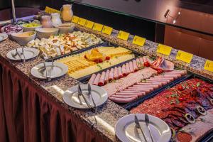 a buffet line with different types of meats and cheese at Komló Hotel Gyula in Gyula +76 photos