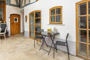a patio with a table and chairs next to a wall at Ferienwohnung in Anni's Ferienhaus in Großaltenstädten