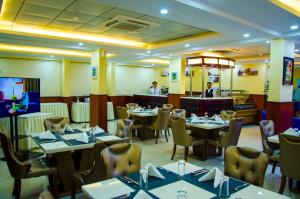 a restaurant with tables and chairs with people in the background at Jubail Inn in Al Jubail