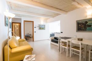 a living room with a yellow couch and a table at Menaggio Tosca Apartments in Menaggio +105 photos