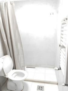a white bathroom with a toilet and a shower at The High Hostel in Budva