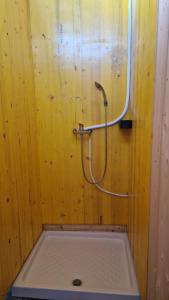 a shower with a hose attached to a wooden wall at Camp Starshine near Bled in Begunje na Gorenjskem