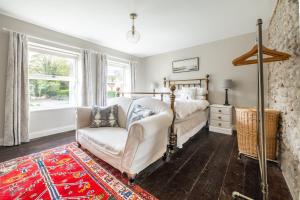 a bedroom with a bed and a couch at Mollies Cottage in Overstrand