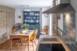 a dining room with a table and a stove at Mollies Cottage in Overstrand