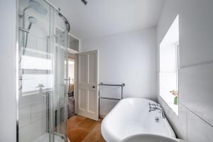 a white bathroom with a shower and a sink at Mollies Cottage in Overstrand +36 photos