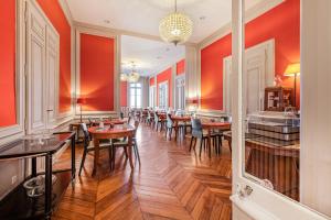 a dining room with tables and chairs and red walls at Best Western Plus d'Europe et d'Angleterre in Mâcon