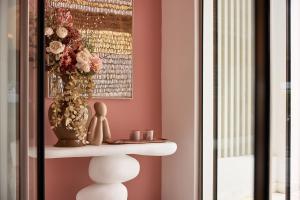 a shelf in a room with a vase of flowers at Tzanis Resort Skyros in Skiros +75 photos