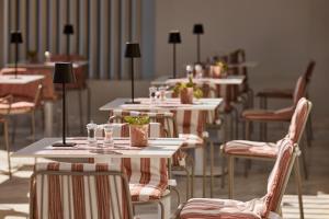 a row of tables and chairs with glasses and plants on them at Tzanis Resort Skyros in Skiros