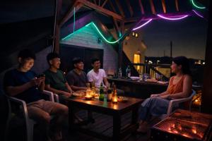 a group of people sitting at a table in a bar at Aloha Beach Deck , Oceanfront, Stunning Sunrises, BBQ, Karaoke in Hokota