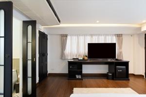 a living room with a flat screen tv on a desk at Bangluang Boutique Hotel nearby Wat Arun in Bangkok