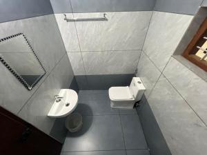 a small bathroom with a toilet and a sink at AMAN Residency in Kallar Vattiyar +33 photos