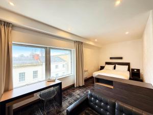 a hotel room with a bed and a large window at Citrus Hotel Cheltenham by Compass Hospitality in Cheltenham