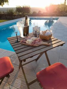 a picnic table with a bottle of wine and cheese at Casinha CB in Casteição