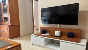a living room with a large television on a wall at PISO AINETXA in Posada de Llanes