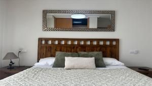 a bedroom with a bed with a mirror on the wall at PISO AINETXA in Posada de Llanes