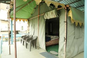 a tent with chairs and a bed in it at Lord Shiva Camps in Sari
