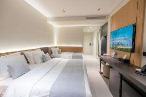 a hotel room with a large bed and a flat screen tv at Padma Hotel in Vlorë