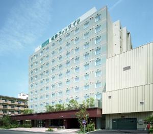 ein großes weißes Hotelgebäude mit in der Unterkunft Sotetsu Fresa Inn Fujisawa Shonandai in Fujisawa