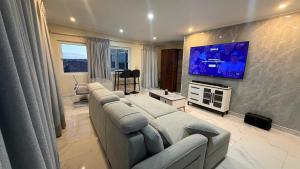 a living room with a couch and a flat screen tv at Modern Studio with Stylish Interior in Dorp Sint Michiel