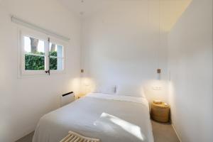 a bedroom with a white bed and a window at Racó 24 in Pals +32 photos