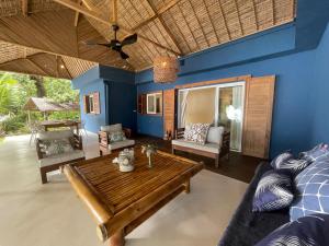 a living room with a wooden table and a couch at Ravenala Lodge, Bungalow et Maison Ile aux Nattes in Ile aux Nattes