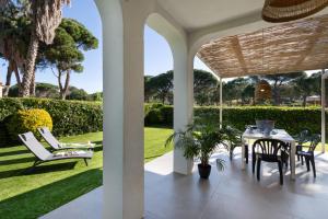 a patio with a table and chairs and a lawn at Racó 24 in Pals
