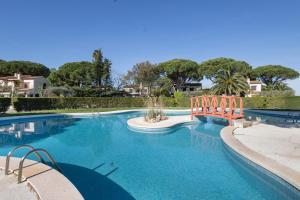 a large swimming pool with a bridge in a yard at Racó 24 in Pals
