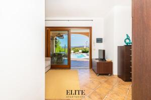 a living room with a door leading to a pool at Elite Collection Domo Mea Private Pool in Olbia