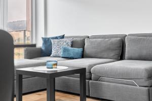 a living room with a couch and a coffee table at Klínovec 301 by Mountain ways in Loučná pod Klínovcem