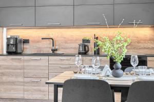 a kitchen with a table with wine glasses at Klínovec 301 by Mountain ways in Loučná pod Klínovcem