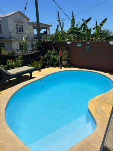 a large blue swimming pool in front of a house at Skipper Dan Bungalow in La Gaulette
