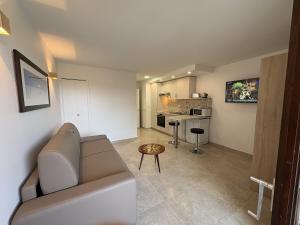 a living room with a couch and a kitchen at Superbe studio terrasse piscine et plage in Fréjus