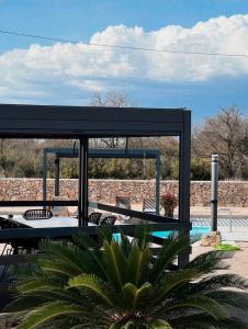 a pavilion with a table and chairs next to a pool at Auto-kamp Dvije suze 1 in Brištane +9 photos