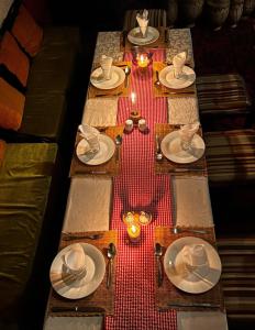 a long table with plates and hats on it at Erg Chebbi Nomad Camp in Merzouga
