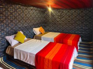 two beds sitting next to each other in a room at Erg Chebbi Nomad Camp in Merzouga +33 photos