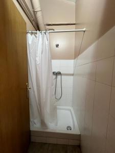 a bathroom with a shower with a white shower curtain at Amaiurko Aterpetxea in Maya del Baztán +19 photos