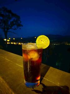a drink sitting on a table with a lemon slice at BaanPhutawanLanta resort & cafe in Ko Lanta