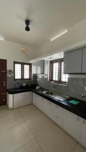 a large kitchen with a black counter top at Souparnika apartments in Varkala
