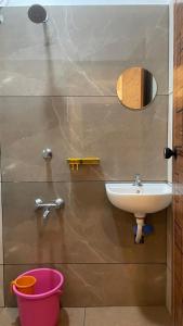a bathroom with a sink and a bucket at Souparnika apartments in Varkala