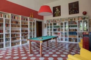 a library with a ping pong table in front of book shelves at Villa Guarienti Valpolicella in Fumane