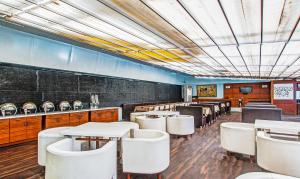 a dining room with white tables and white chairs at Treebo Cherry Tree in Indore